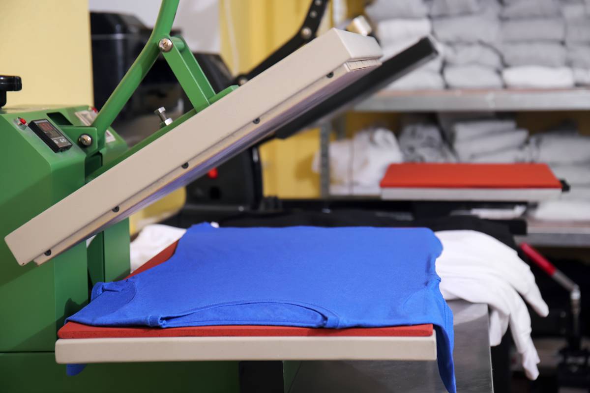Modern printing machine with t-shirt at workplace